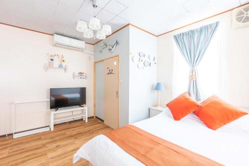 a bedroom with a bed and a flat screen tv at 観光名勝千畳敷徒歩2分 shirahamaペンション千畳嵐 