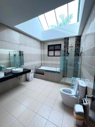 a bathroom with a toilet and a sink and a tub at Dusit Garden Large Pool Villa in Na Jomtien