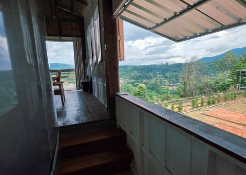 a balcony of a house with a view of the mountains at มานอนนี่แคมป์ เขาค้อ in Khao Kho