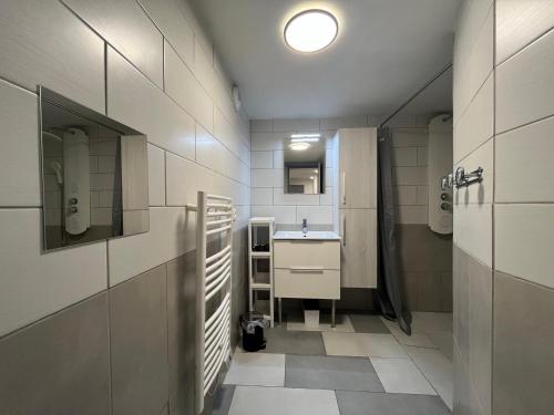 a bathroom with a sink and a toilet and a mirror at Duplex T3 à La Bourboule - Proche thermes, 6 pers - FR-1-608-296 in La Bourboule