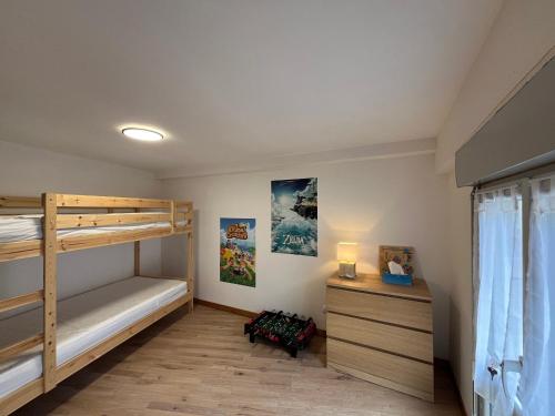 a bedroom with two bunk beds and a dresser at Duplex T3 à La Bourboule - Proche thermes, 6 pers - FR-1-608-296 in La Bourboule