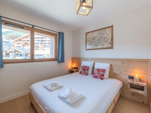 a bedroom with a large bed and a window at Appartement skis aux pieds avec 8 couchages à l'Alpe d'Huez - FR-1-645-96 in L'Alpe-d'Huez