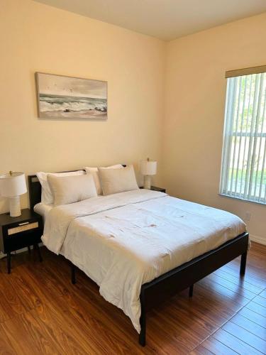Un dormitorio con una cama grande con dos lámparas encima. en Sunshine Suite in Naples, en Naples