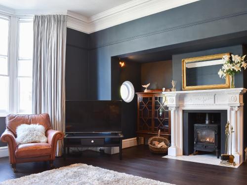 een woonkamer met een open haard en een televisie bij Scarborough Esplanade in Scarborough