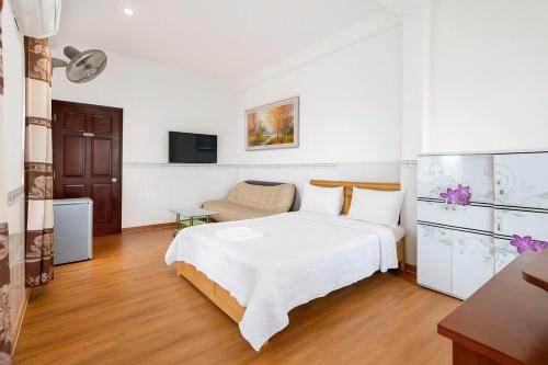 a white bedroom with a bed and a couch at Khách sạn Hoa Anh Anh in Ho Chi Minh City