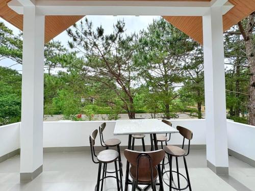 a table and chairs on a porch with a view at HeniSi Hotel Măng Đen (HeniSi 2) in Kon Von Kla