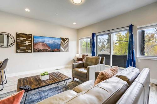 a living room with a couch and a table at 4BD Home w Rooftop Patio Fire Pit & Mountain Views in Colorado Springs
