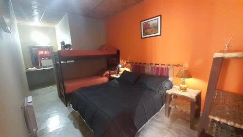 a bedroom with a bed and an orange wall at Los Airampos in Humahuaca