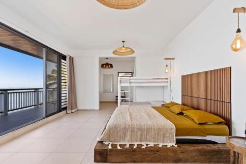 Un dormitorio con una cama y vista al mar. en Spacious 3BR Oceanfront Retreat Paea Tahiti, en Paea