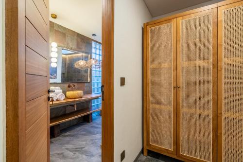 a bathroom with a sink and a wooden door at Villa Domus A1 in Sanur