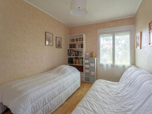 a bedroom with two beds and a book shelf at Maison Charmante 3* à Mimizan: Plages, Pistes Cyclables, Jardin, Wi-Fi, pour 8 Personnes - FR-1-50-137 in Mimizan