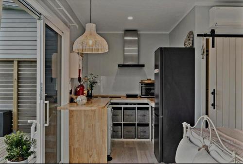 uma cozinha com um frigorífico e um balcão em Stunning Sunsets & Views at Wonderful Wainui em Gisborne