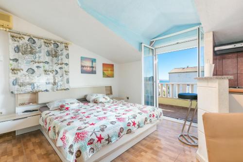 a bedroom with a bed and a balcony at Apartments with parking space Kastel Stafilic, Kastela - 24155 in Kaštela