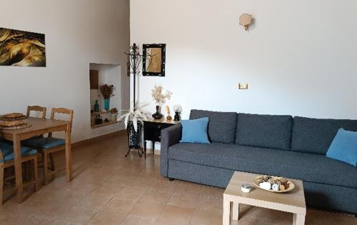 a living room with a blue couch and a table at Etna Garden Francesca in Presa