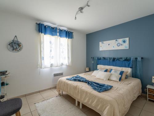 une chambre avec un grand lit aux murs bleus dans l'établissement Maison spacieuse à 600m du lac, 8 pers., piscine - FR-1-50-161, à Aureilhan