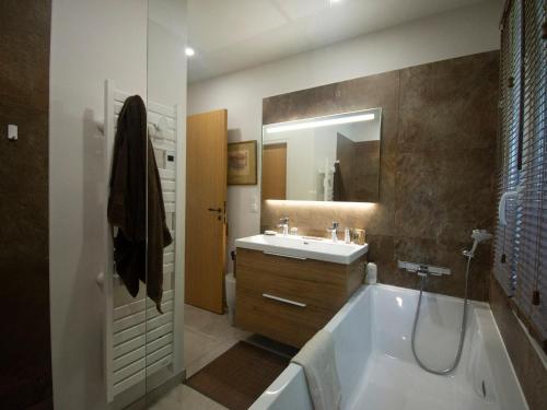 a bathroom with a tub and a sink and a mirror at Carqueiranne: Villa de Charme avec Piscine, Vue Mer, pour 8 Personnes - FR-1-599-119 in Carqueiranne