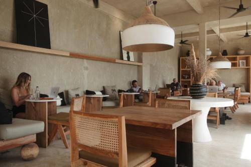 a restaurant with a table and people sitting at tables at The Iggy Hotel Seseh Studio 4 in Cemagi