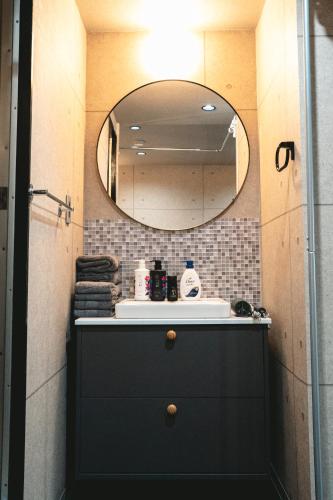 a bathroom with a sink and a mirror at Vinyl Stay - spacious local apartment in Osaka