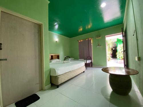 a bedroom with a bed and a table in it at Zackry Guesthouse in Pantai Cenang