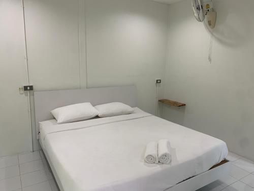 a white bed with two white towels on it at Baan Phuean Koh Kood in Ko Kood
