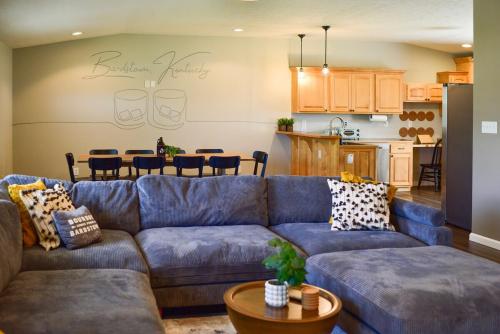 a living room with a blue couch and a kitchen at Bourbon Blue - 8 min to Downtown Bardstown and Spacious! in Bardstown