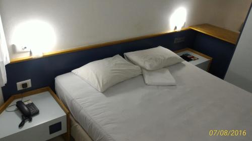 Un dormitorio con una cama con un teléfono. en AP 219 Victory Flat em Tambaú, en João Pessoa