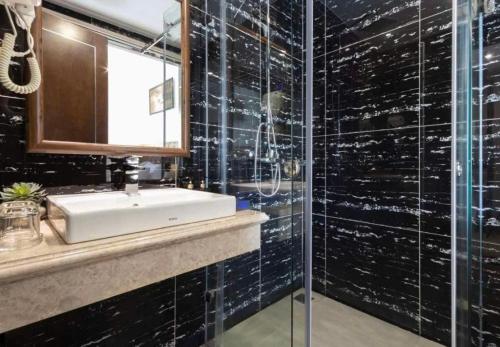 a bathroom with a sink and a glass shower at Sana Da Nang Beach Hotel in Da Nang