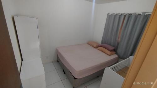 a small room with a small bed and a shower at Casa aconchegante em Garanhuns in Garanhuns