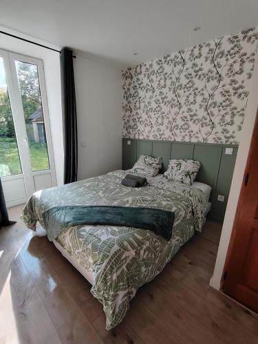 ein Schlafzimmer mit einem Bett mit grünem Kopfteil in der Unterkunft Cocon confort 