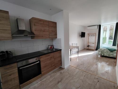 eine Küche mit Holzschränken und ein Wohnzimmer in der Unterkunft Cocon confort 