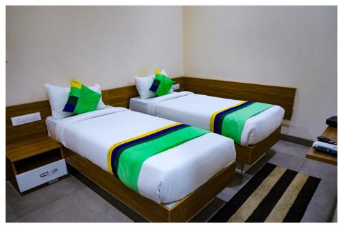 zwei Betten in einem kleinen Zimmer mit sidx sidx sidx sidx in der Unterkunft Purple orchid in Bangalore