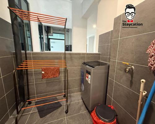 a bathroom with a shower and a trash can at Staycation Homestay 77 D'Millenia near UNIMAS in Kuching