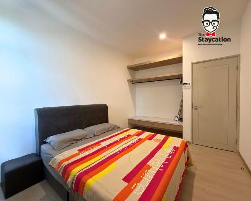 a bedroom with a bed with a colorful blanket at Staycation Homestay 77 D'Millenia near UNIMAS in Kuching