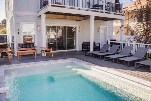 una piscina en un patio con sillas y una casa en Family Beach House with Pool - Blocks From Beach, en Jacksonville Beach