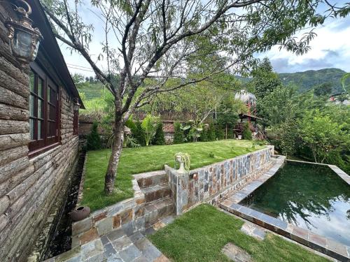 a backyard with a stone retaining wall and a lawn at Vi's House - Nature in the middle of Hmong village in Sa Pa