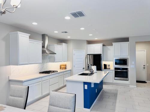 a kitchen with white cabinets and a blue island at Friendly Host Near Loop 202 with Mountain views in Phoenix
