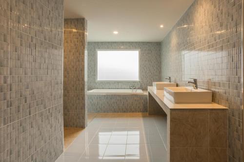 a bathroom with a sink and a tub and a window at First Ao Nang Private Pool Villa in Ao Nang Beach