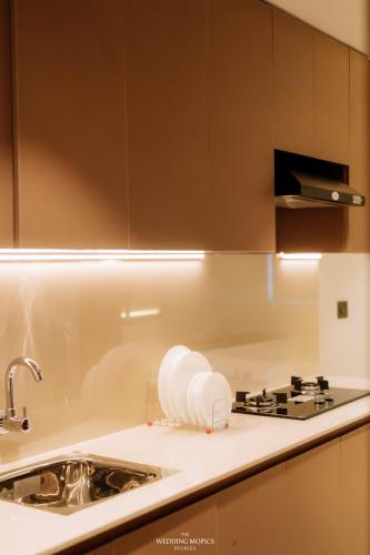a kitchen counter with a sink and a stove at Alite Enclaves Fully furnished apartments in Trichūr
