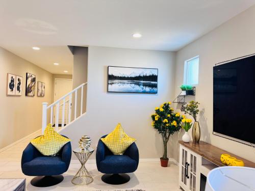 a living room with two blue chairs and a flat screen tv at Friendly Host Near Loop 202 with Mountain views in Phoenix