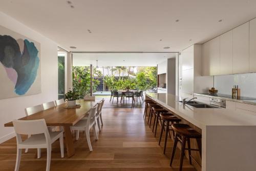 an open kitchen and dining room with a wooden table and chairs at Alpha Luxe - Pet Friendly Luxury Home and Heated Pool in Byron Bay