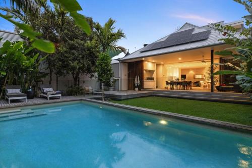 a swimming pool in front of a house at Alpha Luxe - Pet Friendly Luxury Home and Heated Pool in Byron Bay