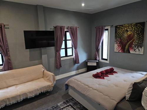 a bedroom with two beds and a flat screen tv at Beautiful New 3 Bed 3 Bathroom Villa 400m to Bang Tao Beach Sleeps 9 in Ban Thalat Choeng Thale