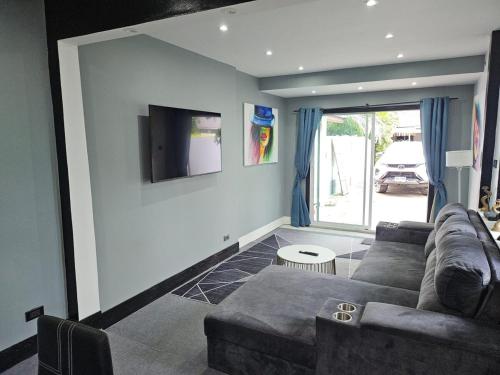 a living room with a couch and a flat screen tv at Beautiful New 3 Bed 3 Bathroom Villa 400m to Bang Tao Beach Sleeps 9 in Ban Thalat Choeng Thale
