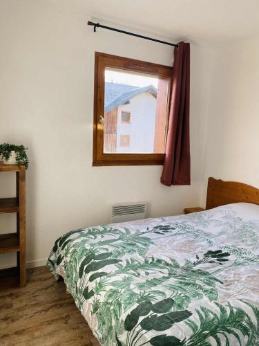 a bedroom with a bed and a window at Appartement super Devoluy in Le Dévoluy