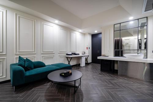 un salon avec un canapé vert et une table dans l'établissement Boutique Hotel XYM Pyeongtaek, à Pyeongtaek