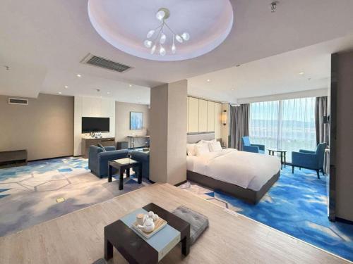 a hotel room with a bed and a living room at Nanning Champs Elysees Hotel in Nanning