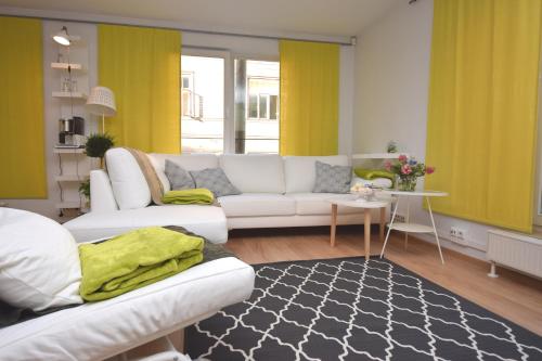 sala de estar con sofá blanco y cortinas amarillas en Bright Home en Tallin