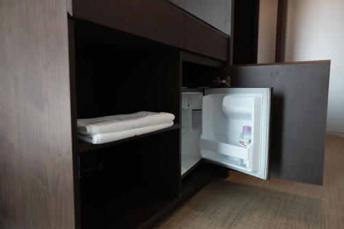 a small refrigerator with a bottle of detergent in it at Jeju Stay in Sungsan in Seogwipo
