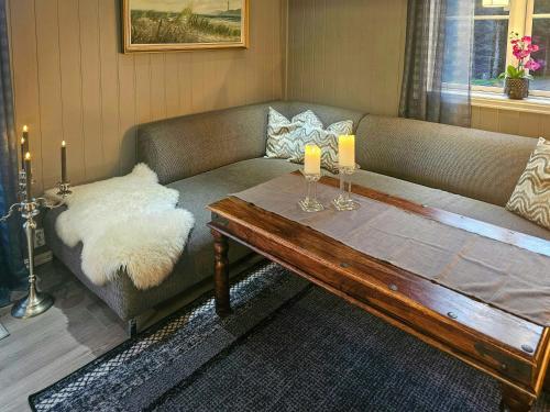 a living room with a couch and a wooden table at Charming Farm Stay On Averøy Island in Lyngstad