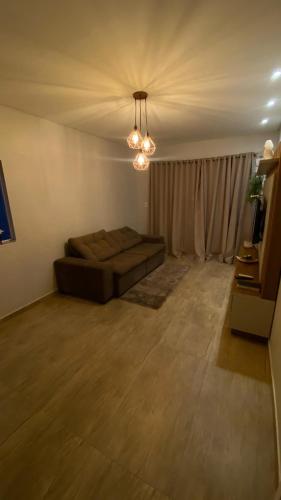 a living room with a couch and a chandelier at Casa da Gih in Penha
